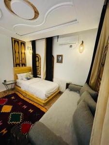 a bedroom with a bed and a couch in a room at Dar Rihana Dadès in Aït Idaïr