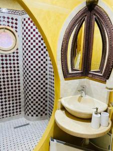 a bathroom with a sink and a mirror at Dar Rihana Dadès in Aït Idaïr