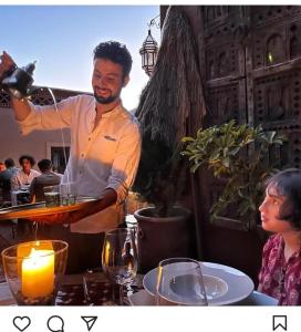 a man holding a tray of wine glasses at Dar Rihana Dadès in Aït Idaïr