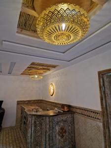 a large chandelier in a restaurant with a table at Dar Rihana Dadès in Aït Idaïr