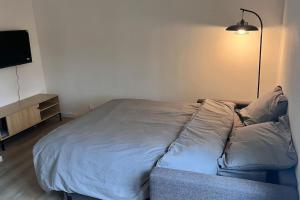 a bed in a room with a lamp and a television at Studio résidence calme in Arcueil