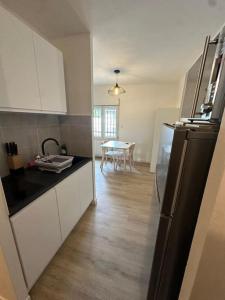 a kitchen with a black refrigerator and a table at Studio résidence calme in Arcueil