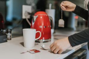 a person preparing a cup of coffee on a kitchen counter at Summerstrand Escape Bella Mare in Gqeberha +57 photos