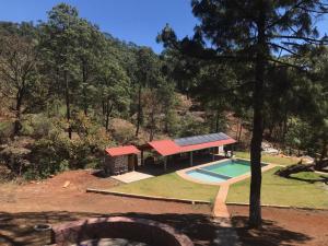 a house with a swimming pool and a pavilion at Cabanas la puente in Mazamitla