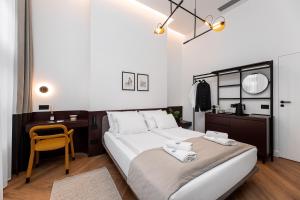een slaapkamer met een groot bed, een bureau en een stoel bij Catalog Boutique Rooms Cluj-Napoca in Cluj-Napoca