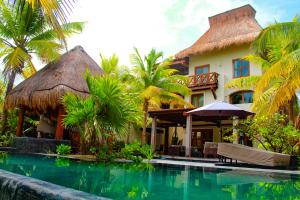 a resort with a swimming pool in front of a building at Delos Luxury Villa in Uaymitun