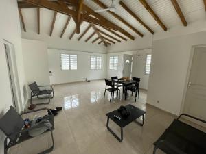 a large living room with a table and chairs at Bethanie in Le Gosier