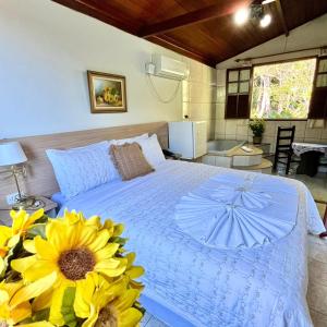 a bedroom with a bed with a sunflower on it at Pousada e Chalés Arco-Íris in Lima Duarte
