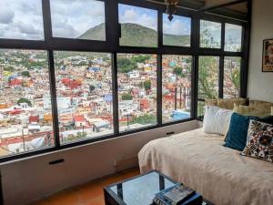 a room with a bed with a view of a city at Spacious Studio Boasting Breathtaking Views in Guanajuato