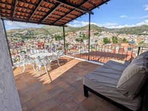 a balcony with a table and chairs and a view of a city at Spacious Studio Boasting Breathtaking Views in Guanajuato +19 photos