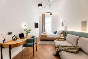 een woonkamer met een bed, een bureau en een bank bij Catalog Boutique Rooms Cluj-Napoca in Cluj-Napoca