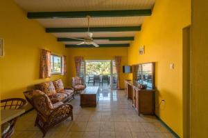 a living room with yellow walls and a ceiling at Club Seru Coral Trupial in Willemstad