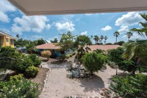 a view of a garden with trees and a house at Club Seru Coral Trupial in Willemstad