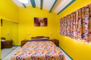 a bedroom with a bed in a yellow wall at Club Seru Coral Trupial in Willemstad