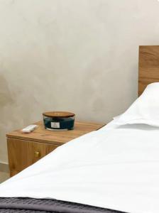 a bedroom with a bed and a wooden nightstand with a white bedspread at Tihanas apartment in Kotor