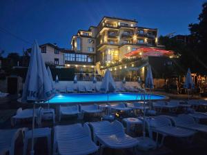 a hotel with a swimming pool with chairs and umbrellas at Комплекс Бабенец in Gorna Oryakhovitsa