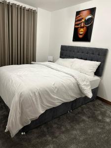 Un dormitorio con una cama grande con un cuadro en la pared. en JEMNACYA Apartments, en Kent