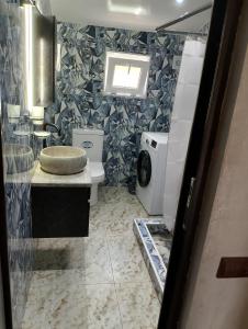 a bathroom with a toilet and a washing machine at Golden Heart in Batumi +7 photos