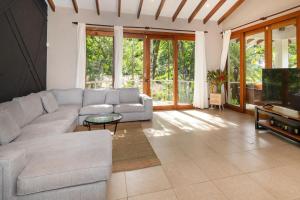 ein Wohnzimmer mit Couch und Fernseher in der Unterkunft Tropical villa Ventanas with private pool in MA in Quepos