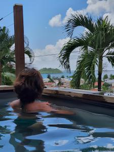 a child in a swimming pool looking out at the ocean at Terrasses avec vue Ilet Ramier in Les Trois-Îlets