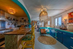 a kitchen with blue cabinets and a counter with chairs at Loft en Tarifa con vistas a África in Tarifa