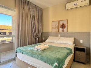 a bedroom with a bed with two towels on it at Residencial 364 - Localização privilegiada à 5min da praia in Bombinhas