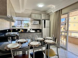 a dining room with a table and chairs in a kitchen at Residencial 364 – Prime Location, Just 5 Minutes from the Beach in Bombinhas
