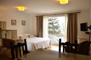 Dormitorio con cama y ventana con árbol de Navidad en Majuto en San Carlos de Bariloche