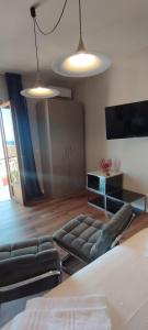Un dormitorio con una cama, un sofá y un televisor. en Glamour suite, en Monopoli
