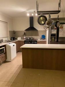 a kitchen with a stove and a counter with pots and pans at Family home close to Melb Airport, free FAST WIFI! in Craigieburn