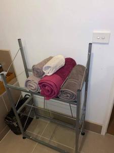 a towel rack with a bunch of towels on it at Family home close to Melb Airport, free FAST WIFI! in Craigieburn