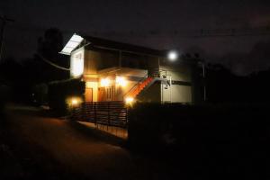 um pequeno edifício com luzes acesas à noite em Themapleview em Ooty