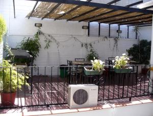 a patio with a table and chairs and a fan at Hostel Lagares in Mendoza