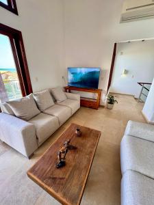 ein Wohnzimmer mit einer Couch und einem Couchtisch in der Unterkunft CASA TAÍBA BEACH RESORT PÉ Na AREIA - IMOB TEMPORADA in Taíba + 36 Fotos