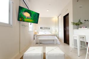 Habitación con cama y TV en la pared. en Cozy Loft, Few Meters From Mariscal Lopez, en Asunción