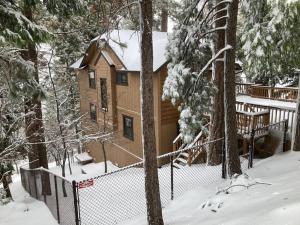 a log cabin in the woods in the snow at Cozy 3BR Dog-Friendly Cabin- Level 2 EV Chgr in Lake Arrowhead
