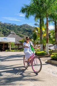 a woman riding a pink bike down a street at La Dulce Vista Hotel & Villas - Sierra Madre Puerto Vallarta in Puerto Vallarta