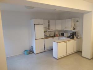 una cocina vacía con armarios blancos y nevera en Hostelli tornihovi, en Kouvola