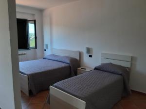 a bedroom with two beds and a window at Colle Vermiglio in Paterno Calabro