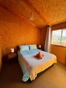 una camera da letto con un letto con due asciugamani sopra di Cabañas Sin Limites a Puerto Ingeniero Ibáñez
