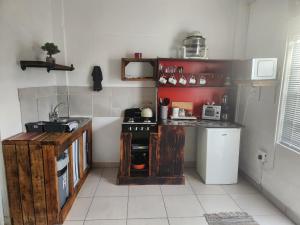 Una pequeña cocina con estufa y fregadero. en Beauty Max, en Hermanus 17 fotos más