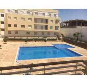 a large swimming pool in front of a building at Appartement à Cap de l'eau, vue piscine in Ras El Ma