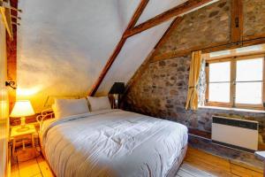 a bedroom with a bed and a window at Maison Bilodeau Ethier - 5 chambres - 13 personnes in Saint-Férréol-les-Neiges +17 photos