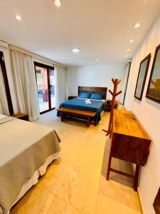 ein Schlafzimmer mit einem Bett und einem Tisch darin in der Unterkunft CASA TAÍBA BEACH RESORT PÉ Na AREIA - IMOB TEMPORADA in Taíba