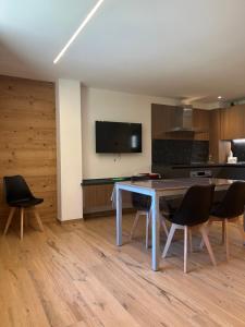 a kitchen with a table and chairs and a tv at Baita del Sole in Vermiglio