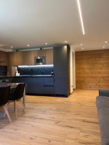 a living room with a table and a kitchen at Baita del Sole in Vermiglio
