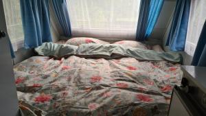 un letto non rifatto in una stanza con finestra di B&B De Vretberg a Enschede Altre 30 foto