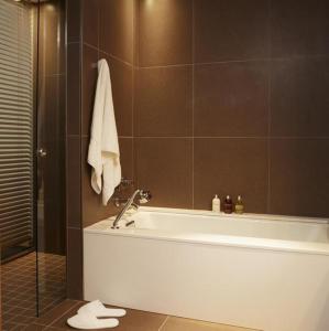 a bathroom with a bath tub and a shower at Le Germain Hotel Maple Leaf Square in Toronto