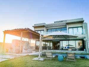 une maison avec deux chaises et un parasol dans l'établissement Casa Vista Mar, Piscina Aquecida/Hidro, Cozinheira, à Barra do Camaragibe