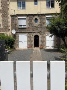 un edificio con puertas blancas delante de él en Appart de Manuela, en Saint-Malo